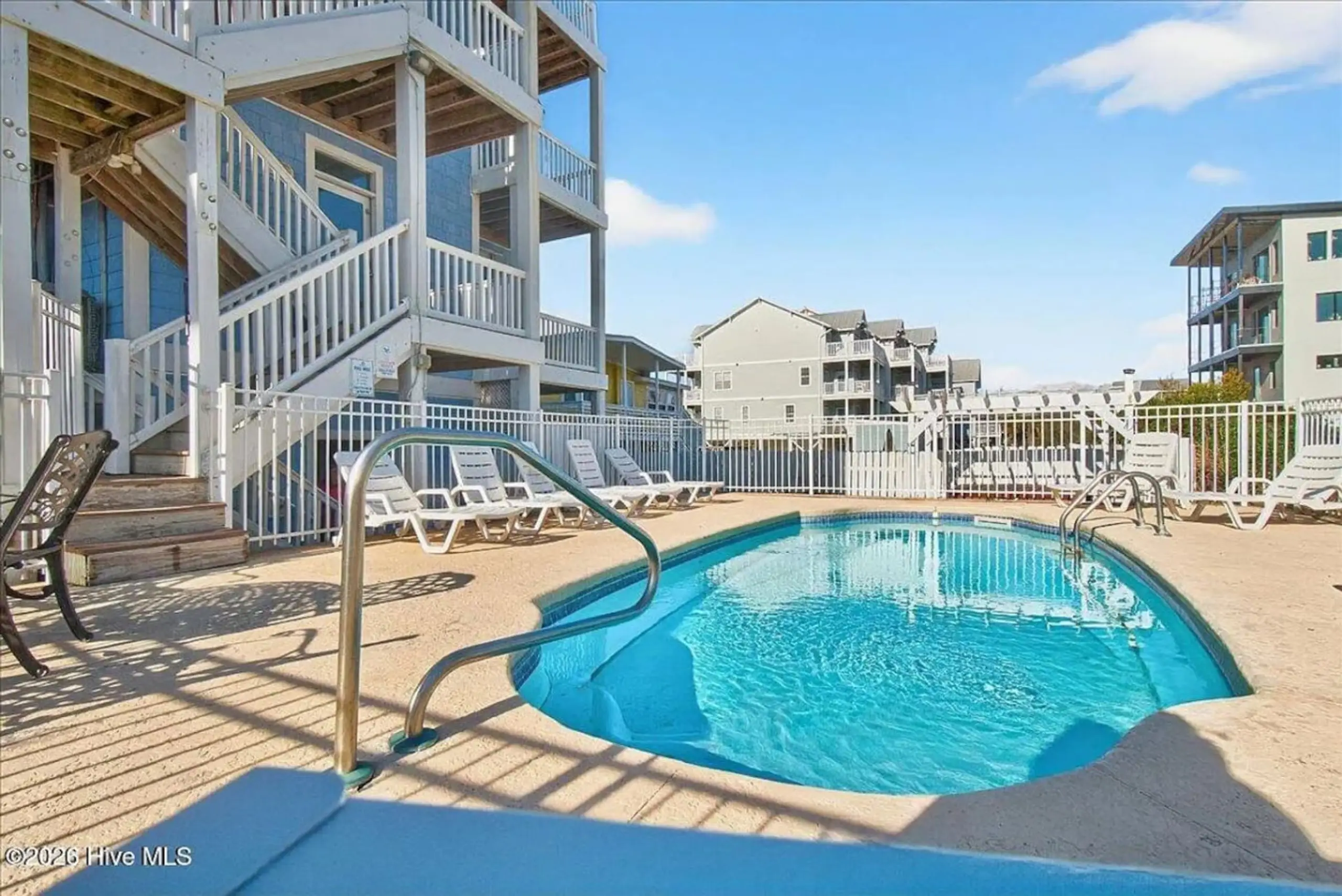 Outdoor pool with lounge chairs at condos