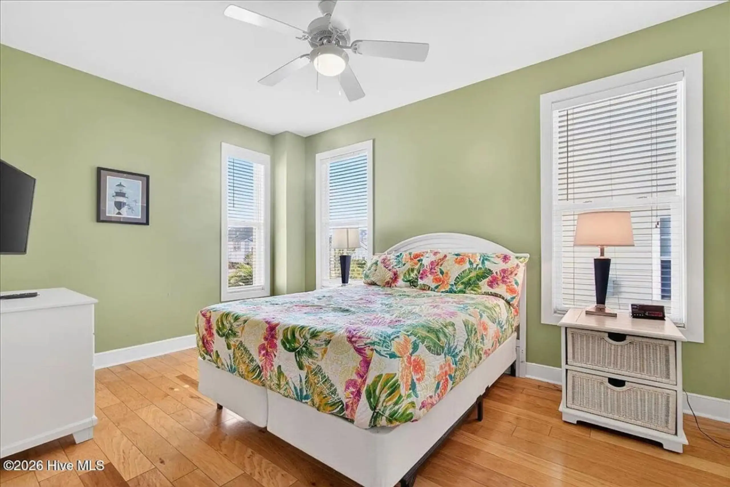 Bright bedroom with floral bed and green walls